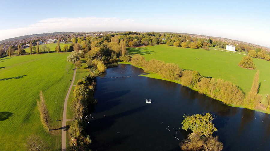 Danson Park lake with trees and open parkland in Bexley